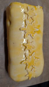 In Blätterteig eingeschlagenes Beef Wellington, mit Eigelb bestrichen und mit Schneeflocken aus Teig verziert